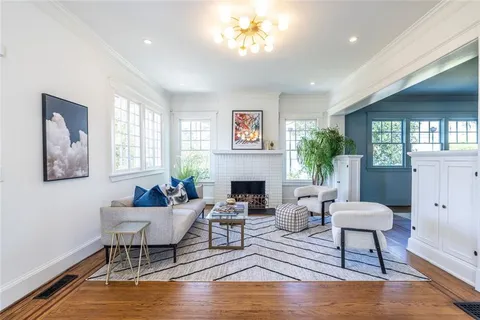 a living room with fireplace furniture and a large window