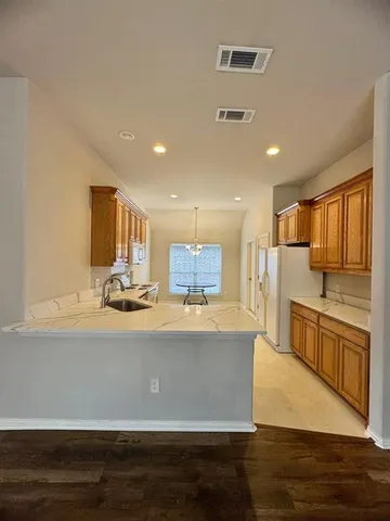 a large kitchen with stainless steel appliances a large counter top a stove and a refrigerator