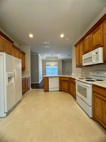 a large kitchen with stainless steel appliances granite countertop a stove a sink and a microwave