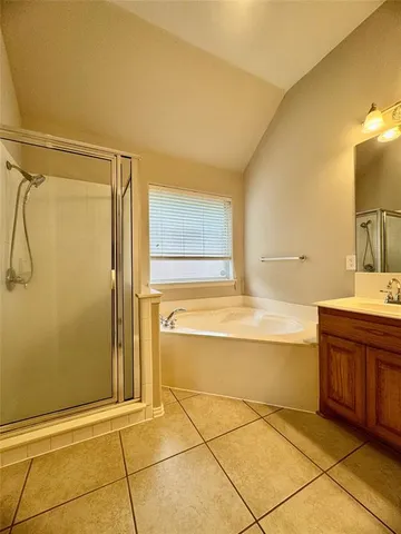 a spacious bathroom with a tub sink and mirror