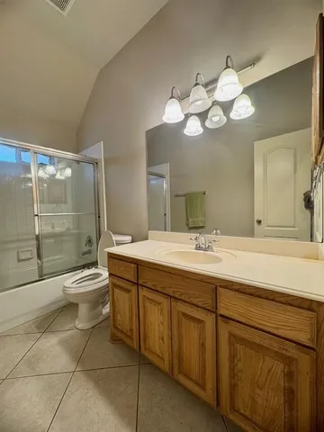 a bathroom with a granite countertop sink a toilet and a mirror