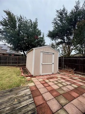 a backyard of a house with large trees and outdoor seating