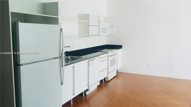 a kitchen with stainless steel appliances a refrigerator and cabinets