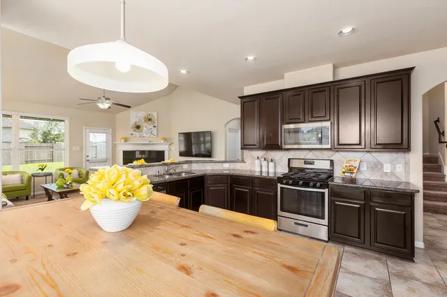 a kitchen with stainless steel appliances kitchen island granite countertop a sink dishwasher stove and cabinets