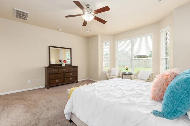 a bedroom with a bed and a ceiling fan