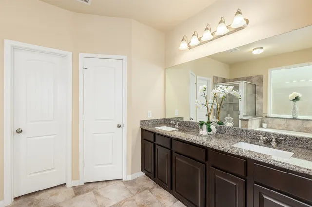 a bathroom with a granite countertop sink and a mirror