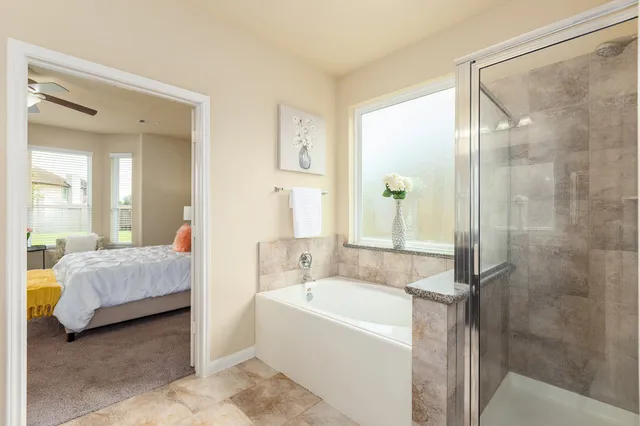a bathroom with a tub shower and sink