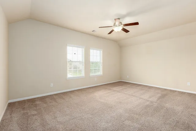 an empty room with windows and ceiling fan view