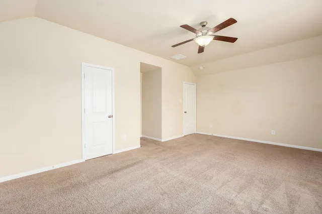an empty room with closet and ceiling fan