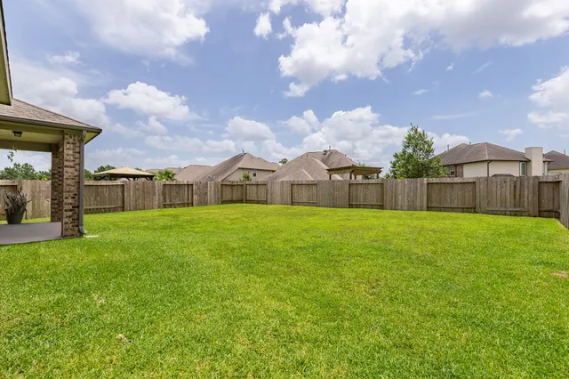 a view of a house with a big yard and a large tree