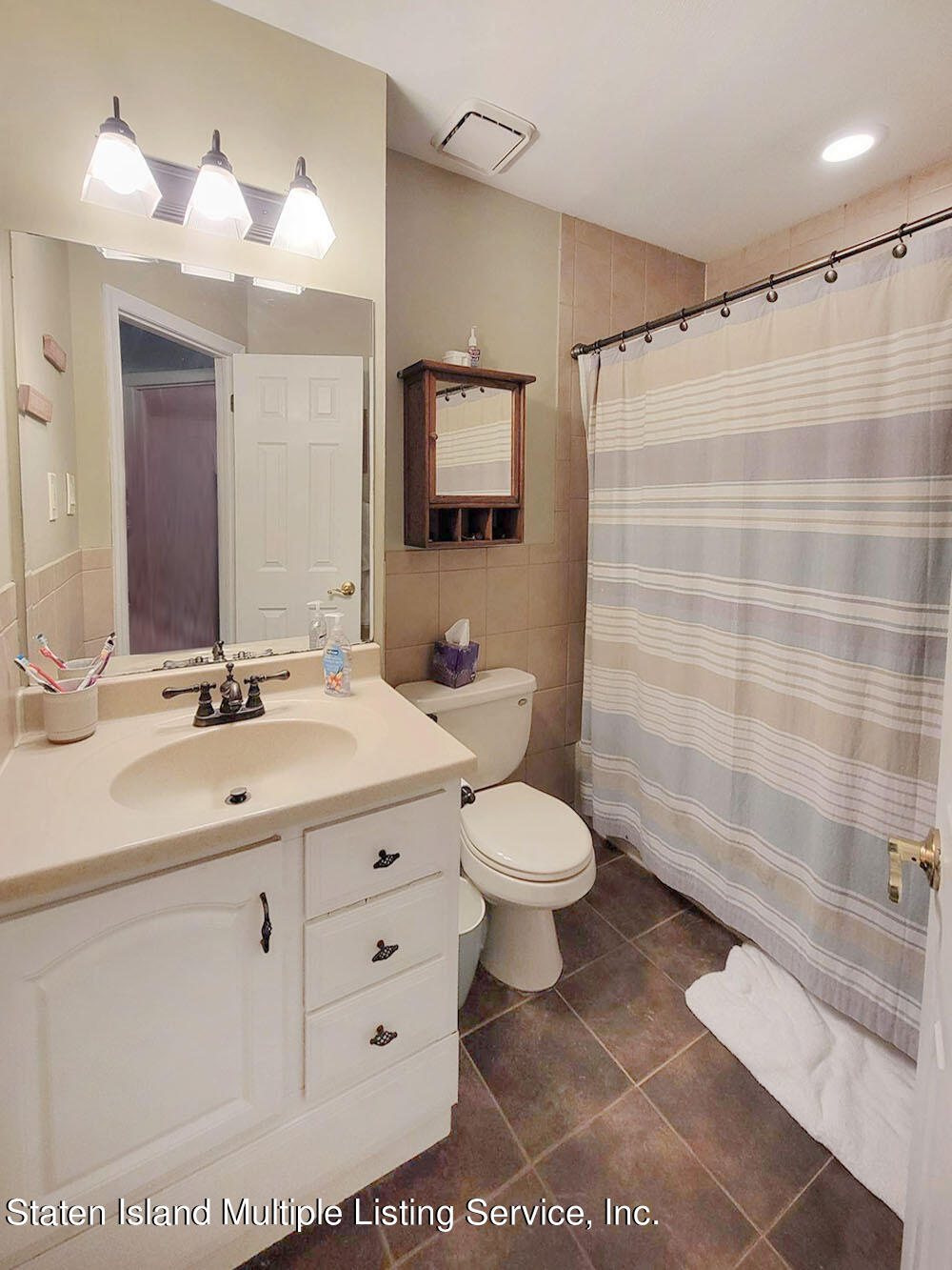 1040 Rathbun Avenue, Unit C Staten Island, NY 10309 - Photo 12 of 17 a spacious bathroom with a sink a toilet a mirror and shower