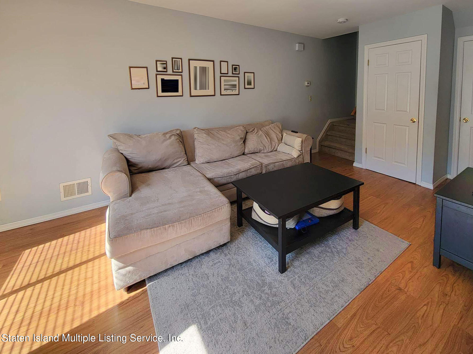 1040 Rathbun Avenue, Unit C Staten Island, NY 10309 - Photo 4 of 17 a living room with a couch and a dresser with wooden floor