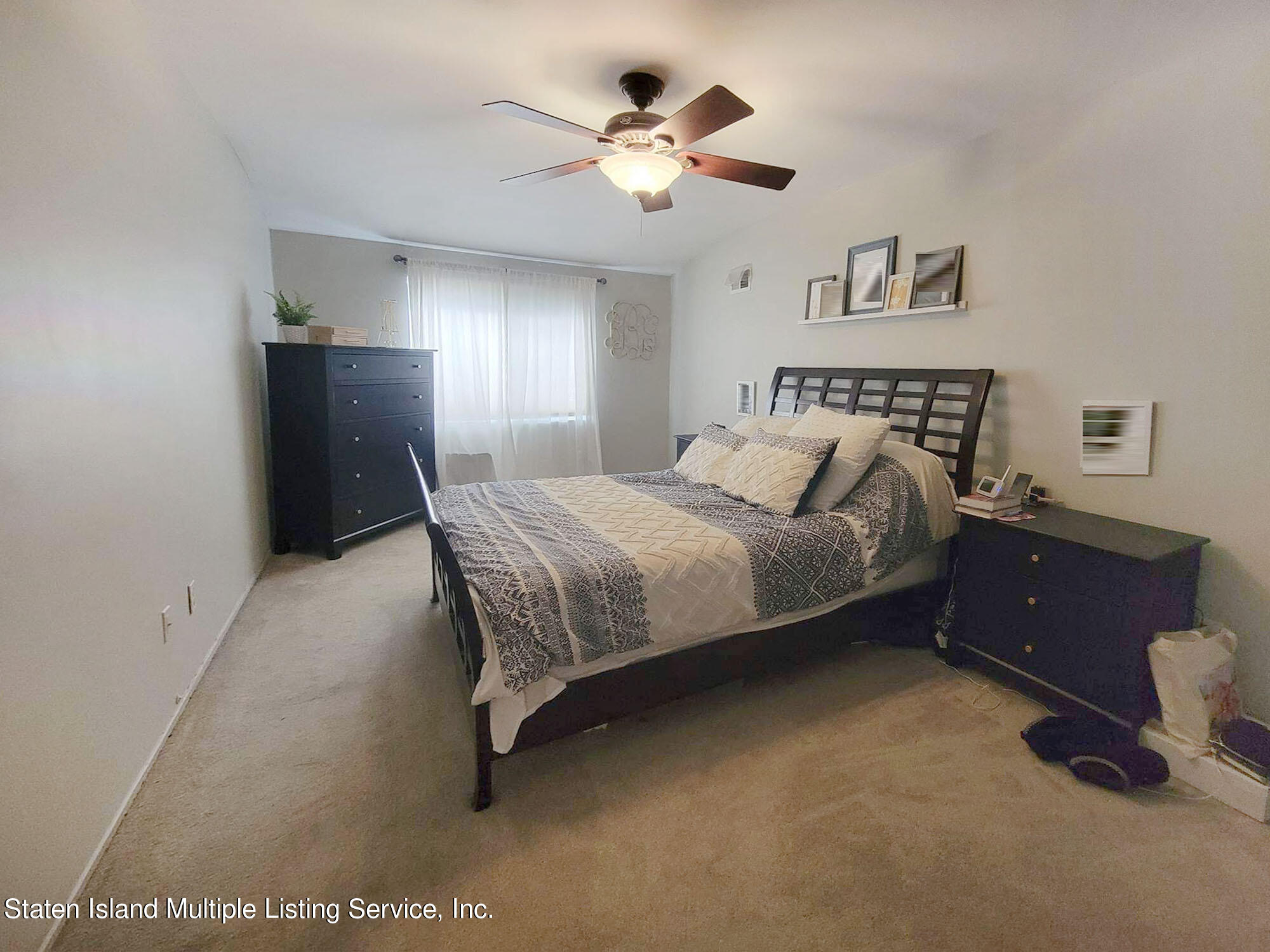 1040 Rathbun Avenue, Unit C Staten Island, NY 10309 - Photo 10 of 17 a bedroom with a bed and a chandelier