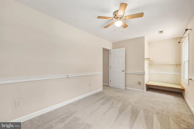 a view of an empty room with a ceiling fan