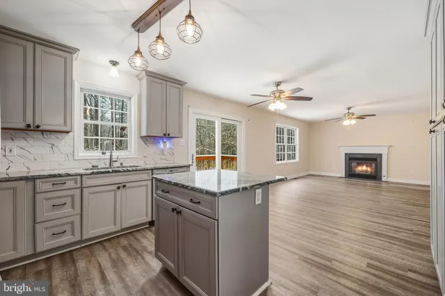 a kitchen with granite countertop a sink cabinets and wooden floor