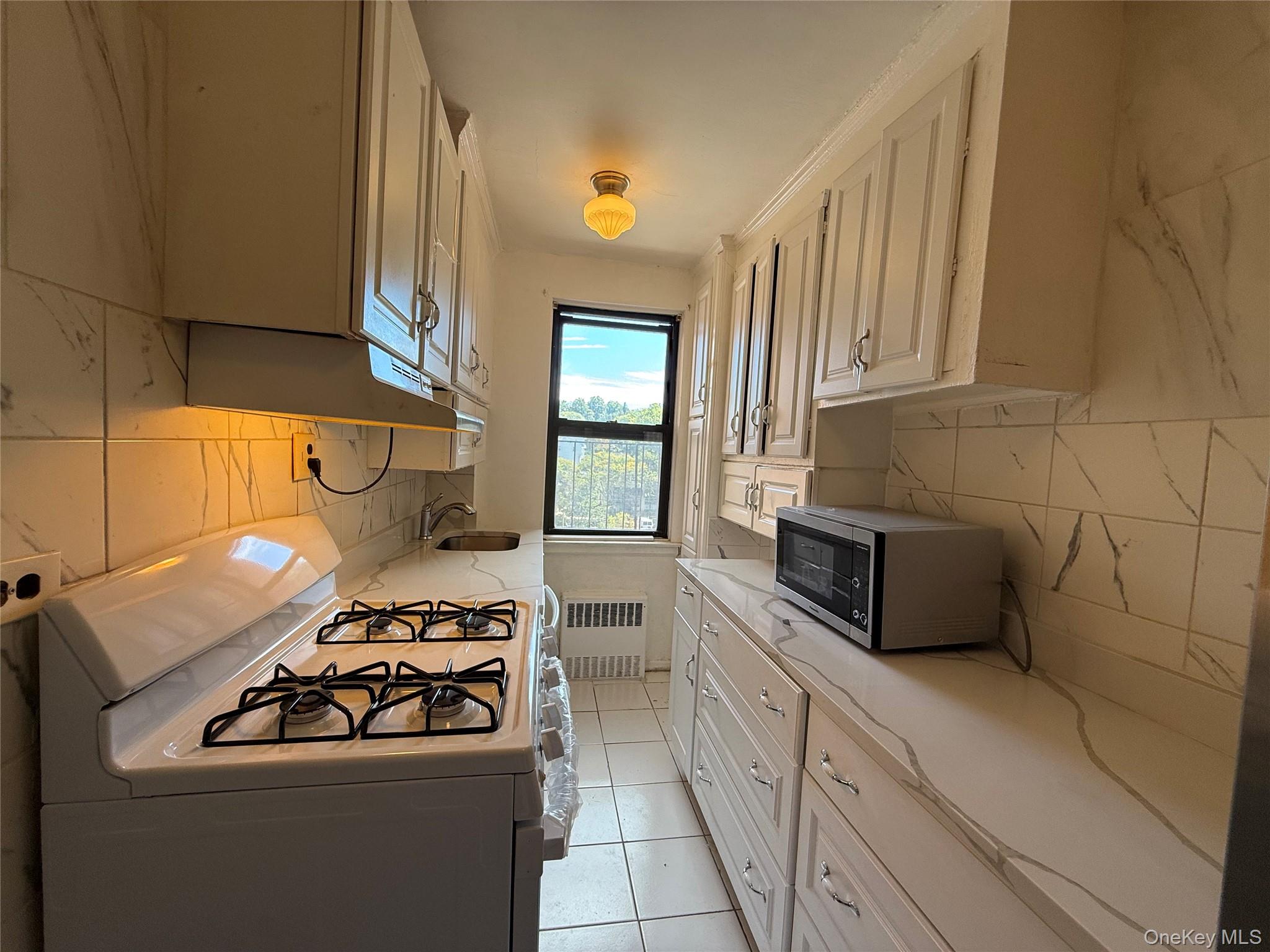 a kitchen with a sink a stove and cabinets