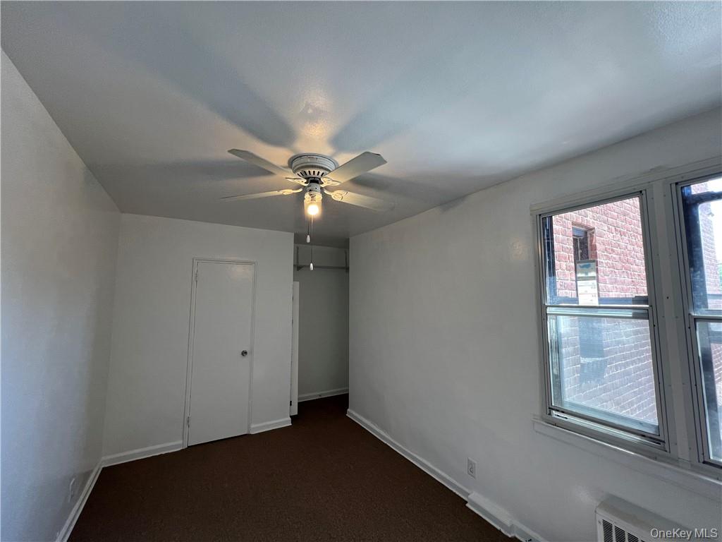 142 Garth Road, Unit 1P Scarsdale, NY 10583 - Photo 11 of 22 an empty room with windows and fan
