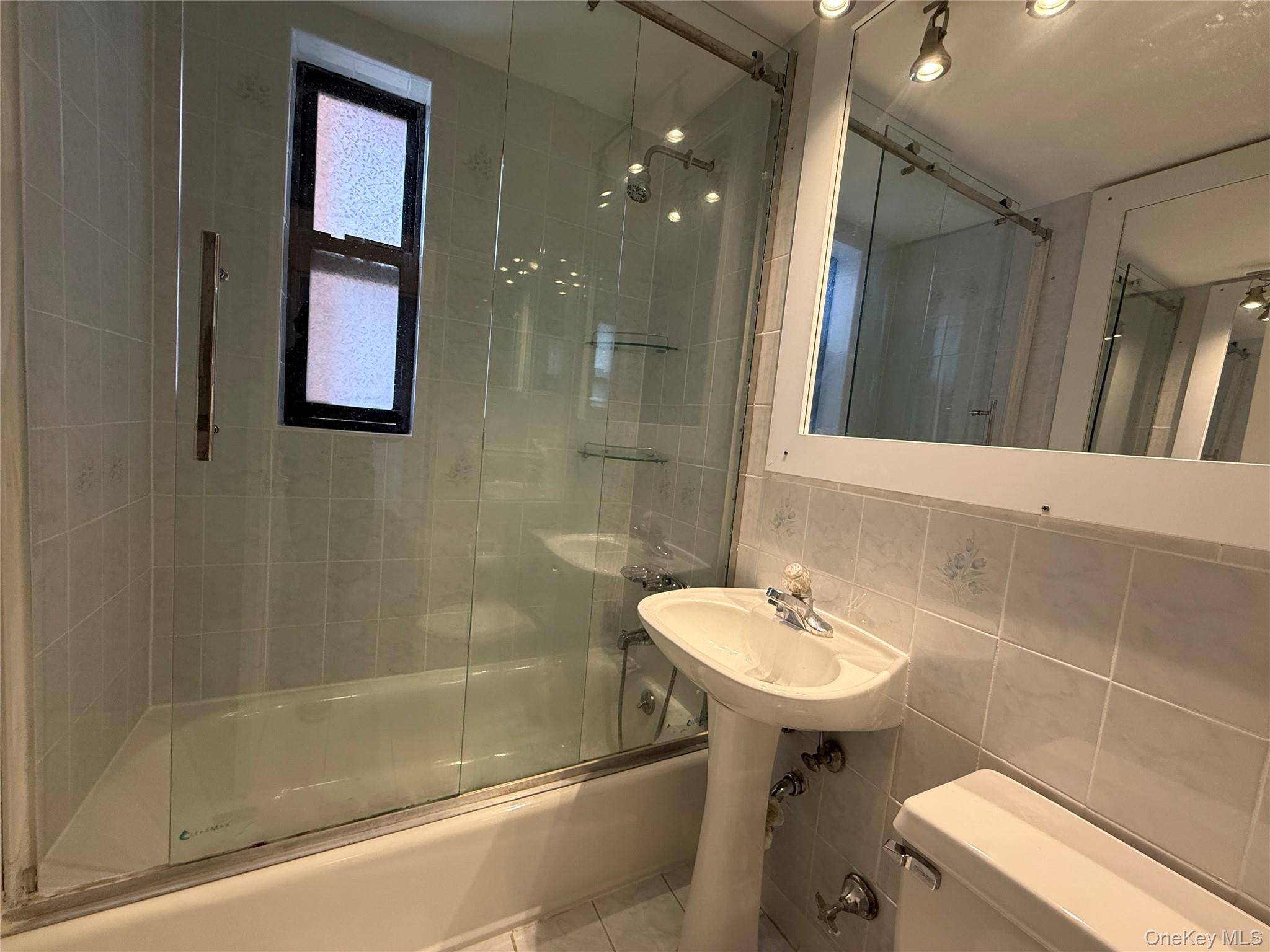 142 Garth Road, Unit 1P Scarsdale, NY 10583 - Photo 15 of 22 a bathroom with a sink a toilet and shower