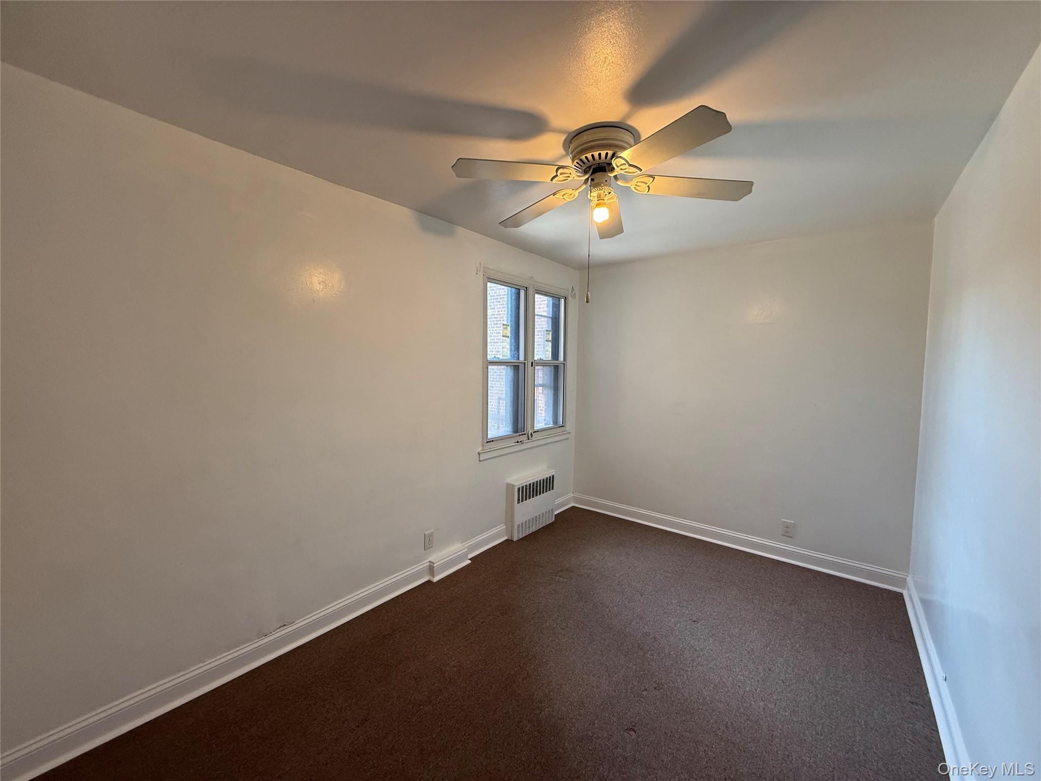 142 Garth Road, Unit 1P Scarsdale, NY 10583 - Photo 18 of 22 an empty room with a window and a fan