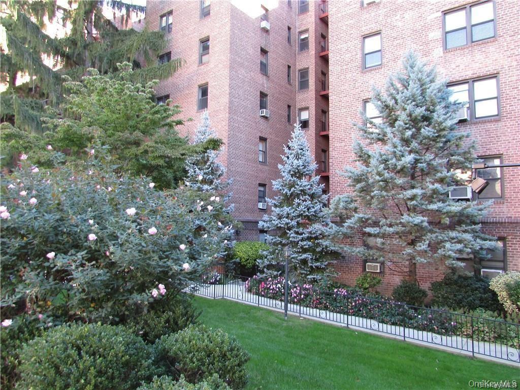 142 Garth Road, Unit 1P Scarsdale, NY 10583 - Photo 2 of 22 a view of a building with a yard