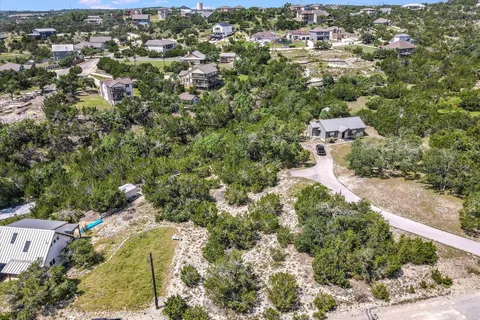 an aerial view of residential house with outdoor space and trees all around
