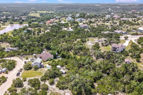 an aerial view of residential houses with city and green space