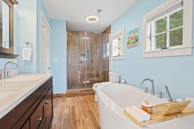 a bathroom with a tub sink and mirror