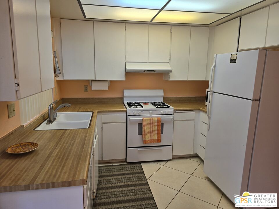 365 West Mariscal Road Palm Springs, CA 92262 - Photo 4 of 25 a kitchen with a refrigerator and white cabinets