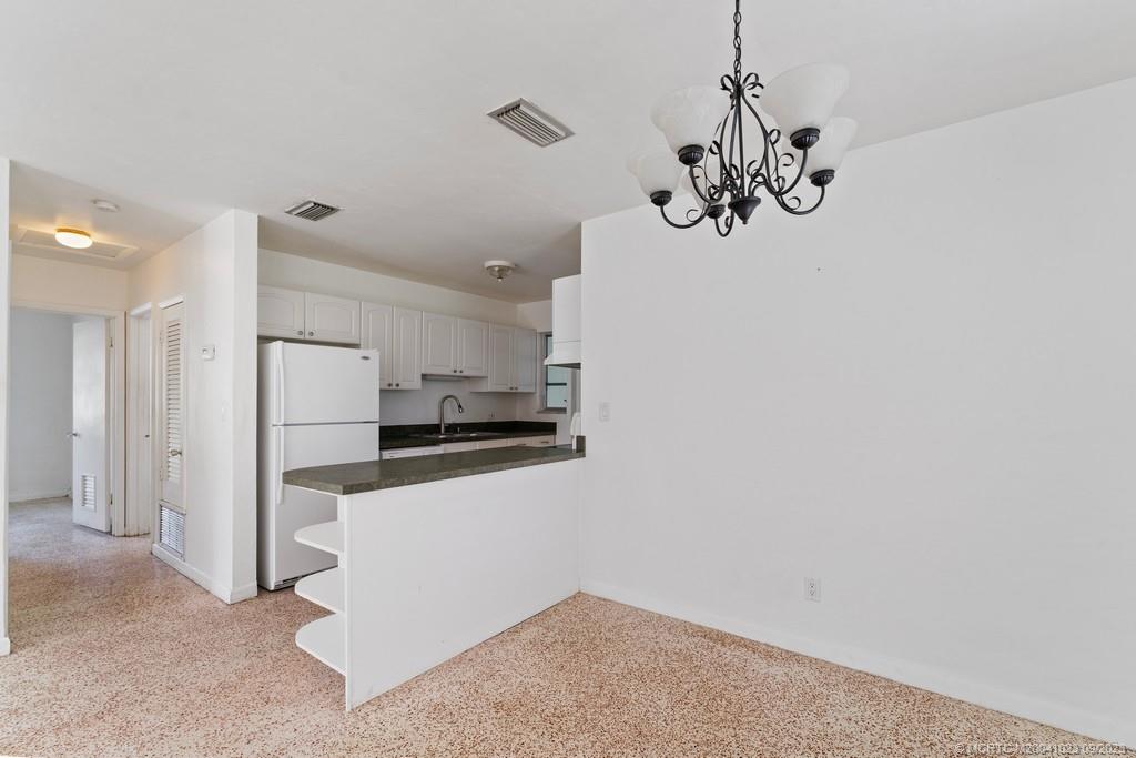 2825 Southeast Pocatella Road Port St. Lucie, FL 34952 - Photo 11 of 36 a view of a kitchen with a refrigerator a microwave and a sink