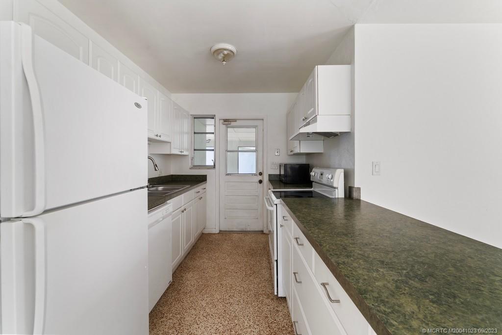 2825 Southeast Pocatella Road Port St. Lucie, FL 34952 - Photo 12 of 36 a kitchen with stainless steel appliances granite countertop a sink stove and refrigerator