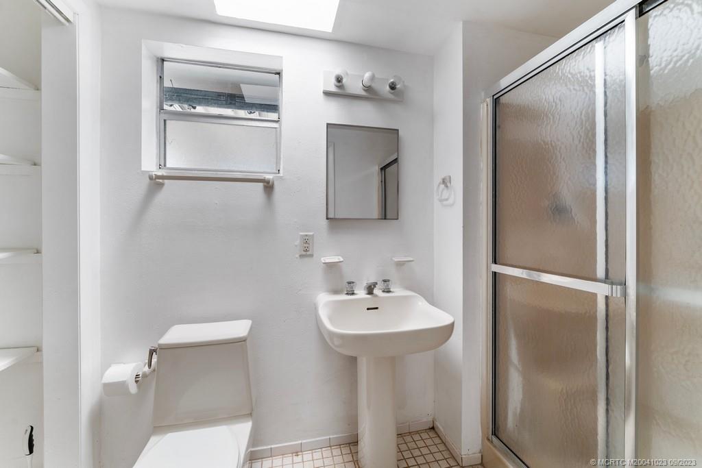 2825 Southeast Pocatella Road Port St. Lucie, FL 34952 - Photo 18 of 36 a bathroom with a sink toilet and mirror