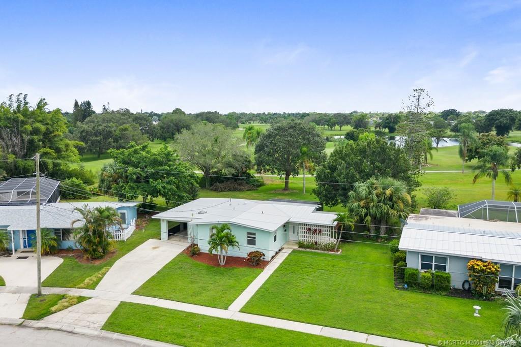2825 Southeast Pocatella Road Port St. Lucie, FL 34952 - Photo 27 of 36 a view of a garden with lawn chairs under an umbrella