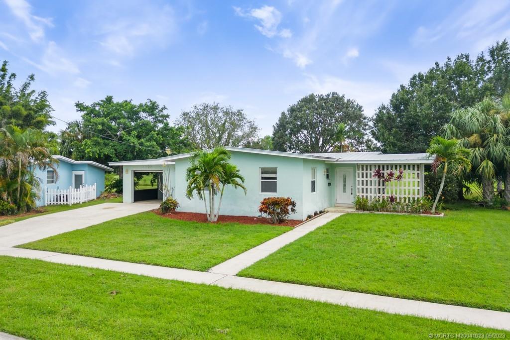 2825 Southeast Pocatella Road Port St. Lucie, FL 34952 - Photo 4 of 36 a front view of house with a garden and trees