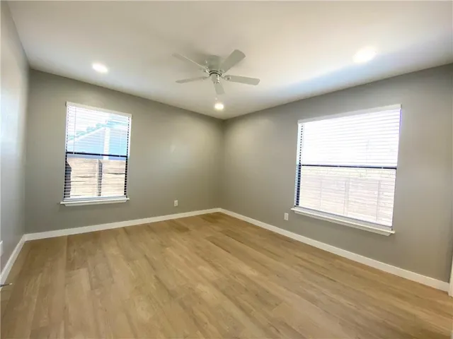 an empty room with a window and ceiling fan
