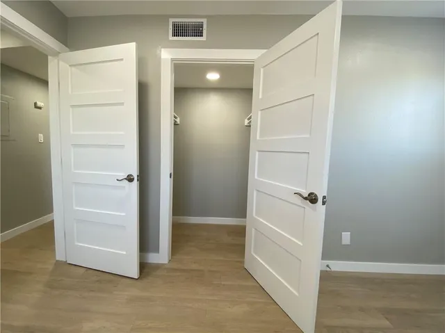 an empty room with closet and wooden floor