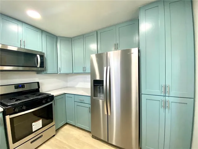 a kitchen with stainless steel appliances granite countertop a refrigerator and a stove top oven
