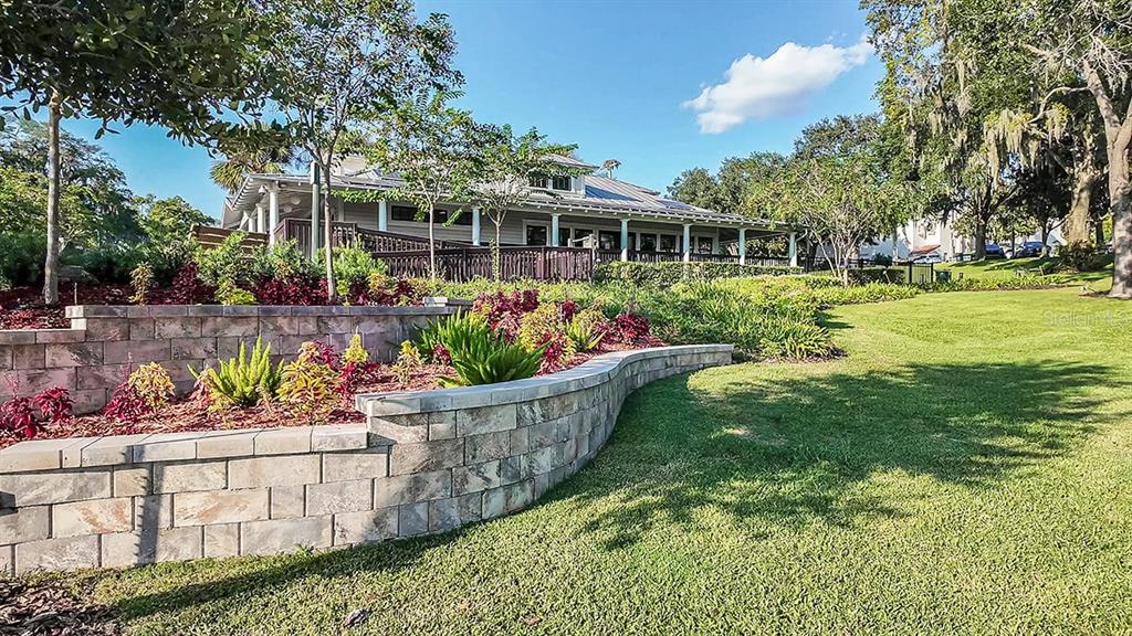 690 Gladstone Way Mount Dora, FL 32757 - Photo 21 of 25 a front view of a house with a yard fountain and a garden