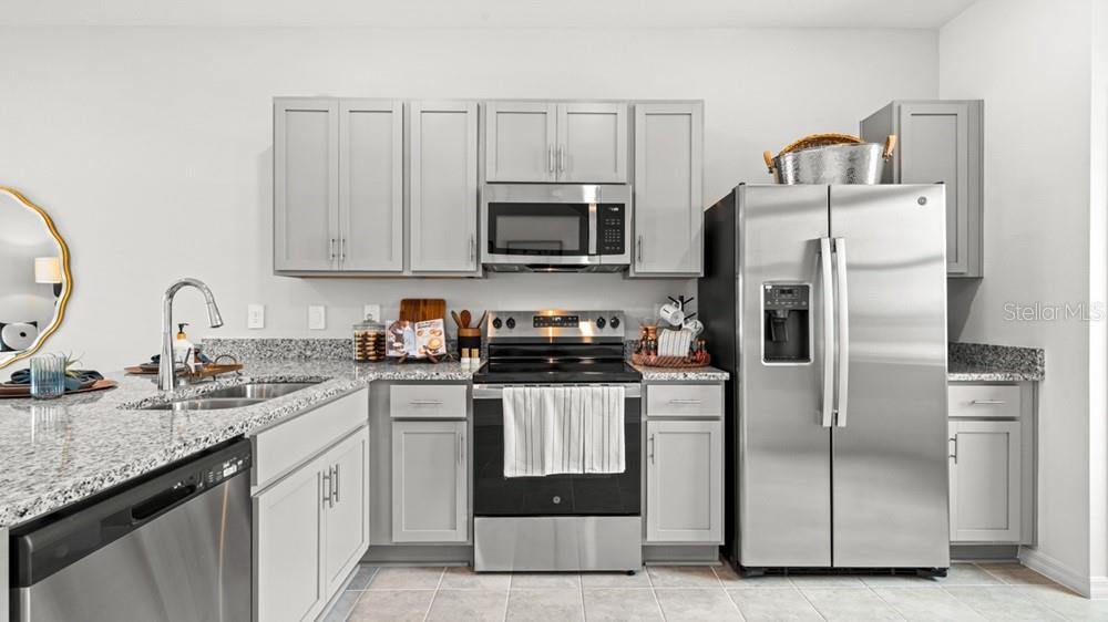 690 Gladstone Way Mount Dora, FL 32757 - Photo 6 of 25 a kitchen with a sink a stove and refrigerator