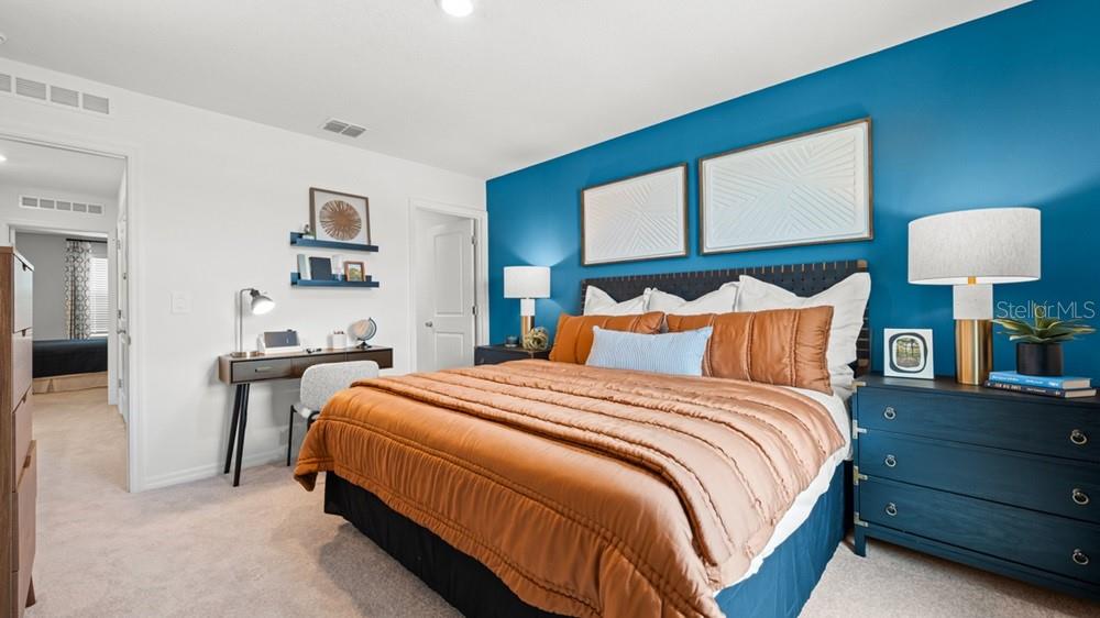 690 Gladstone Way Mount Dora, FL 32757 - Photo 10 of 25 a bedroom with bed and night stand