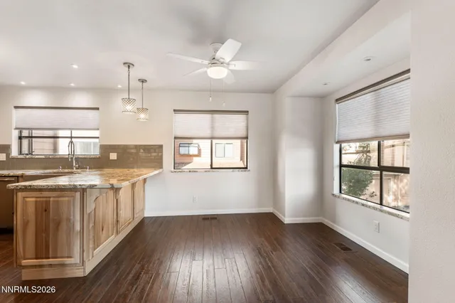a kitchen with stainless steel appliances granite countertop a sink a stove and a wooden floors
