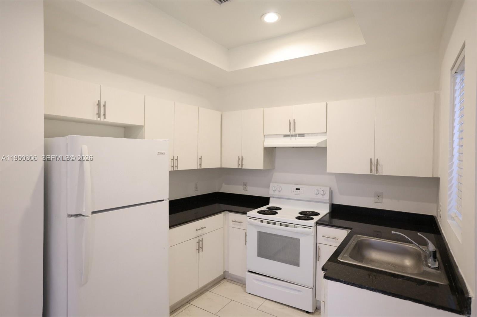 a kitchen with a refrigerator stove and white cabinets