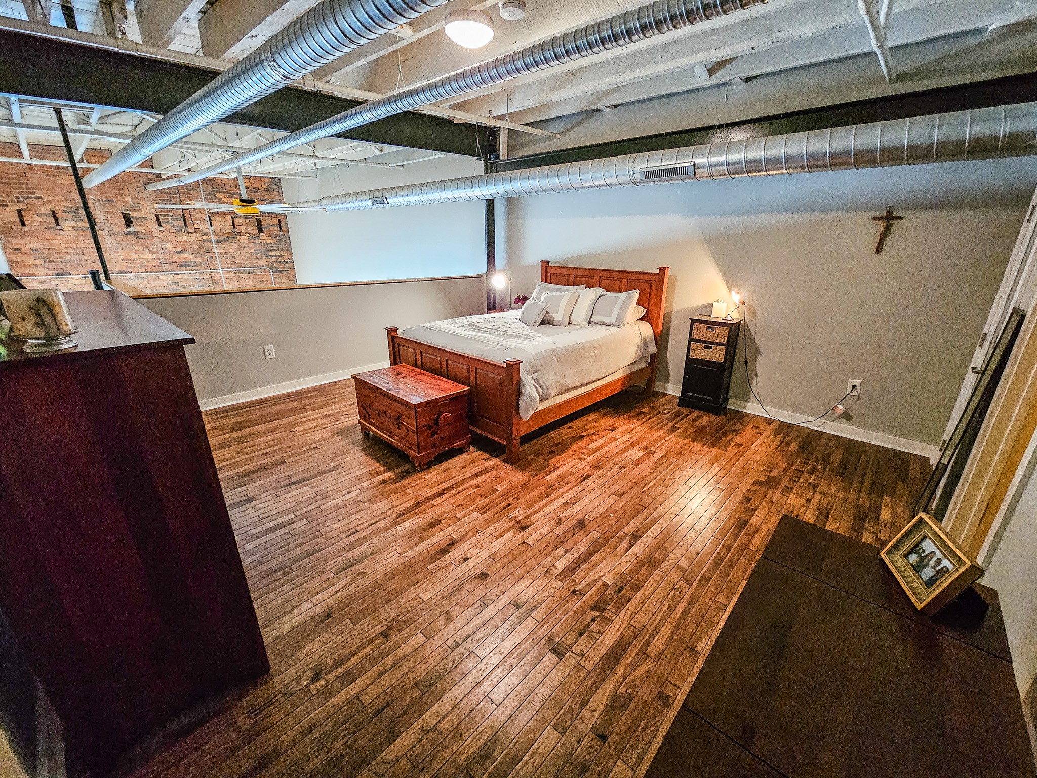 231 Rep. John Lewis Way North, Unit 406 Nashville, TN 37219 - Photo 22 of 30 a bedroom with a bed and wooden floor