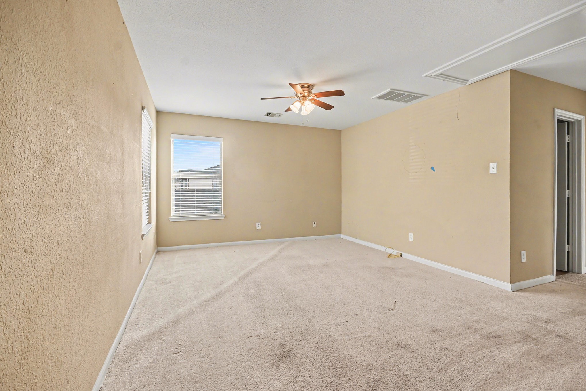 6703 Providence View Lane Houston, TX 77049 - Photo 10 of 21 an empty room with windows and fan