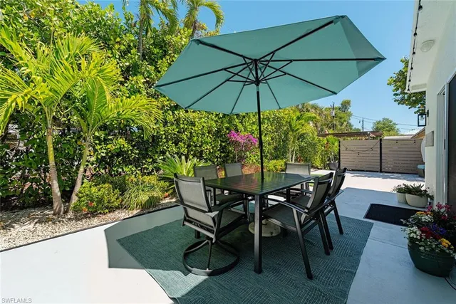 a view of a backyard with furniture and a umbrella