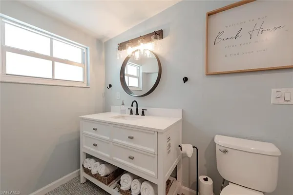 a bathroom with a toilet a sink and a mirror