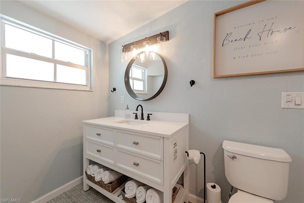 1971 Holiday Lane Naples, FL 34104 - Photo 19 of 26 a bathroom with a toilet a sink and a mirror