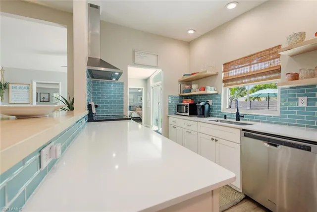 a large kitchen with stainless steel appliances a large window in it