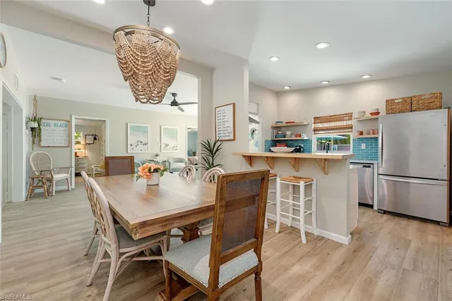 a kitchen with a dining table chairs refrigerator and cabinets