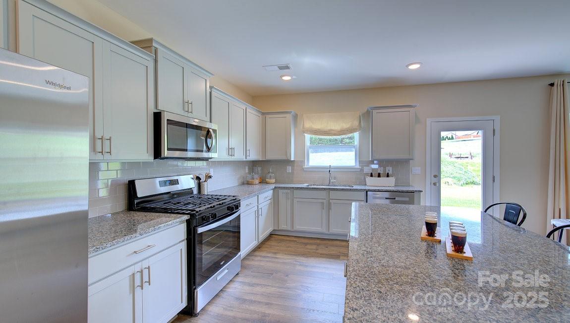 145 Bovine Br Road Fletcher, NC 28732 - Photo 4 of 43 a kitchen with stainless steel appliances granite countertop a stove top oven a sink a counter space and cabinets