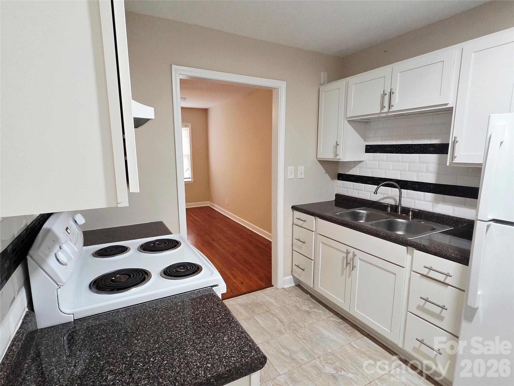 3500 North Sharon Amity Road Charlotte, NC 28212 - Photo 11 of 16 a kitchen with granite countertop a sink a stove and cabinets